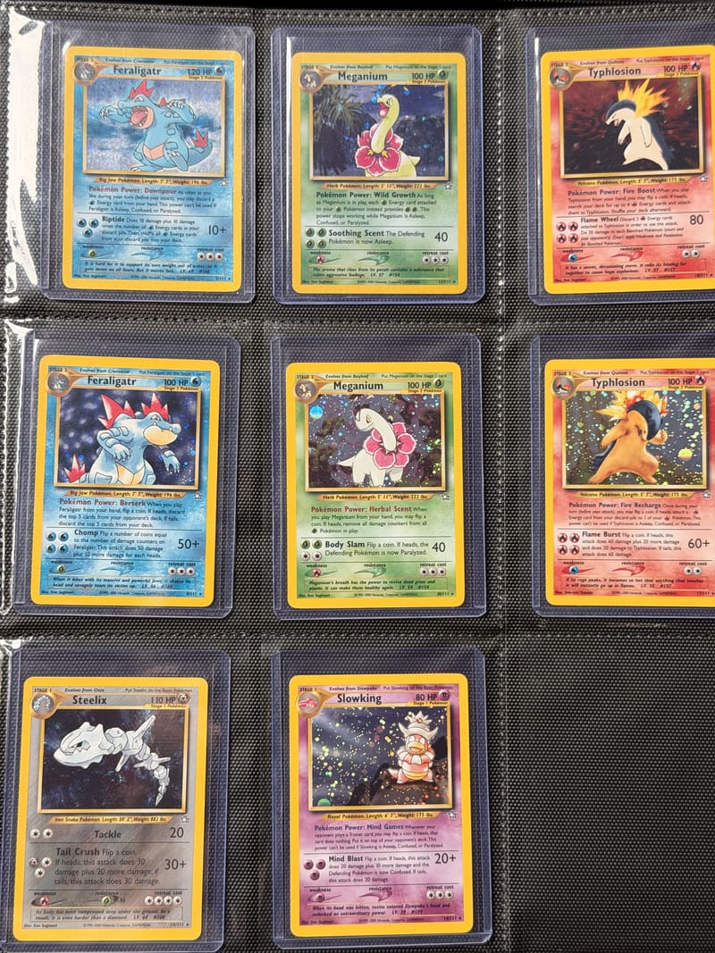 A binder page of Neo Genesis holos: two Feraligatr, two Meganium and two Typhlosion cards with different art, plus Steelix and Slowking